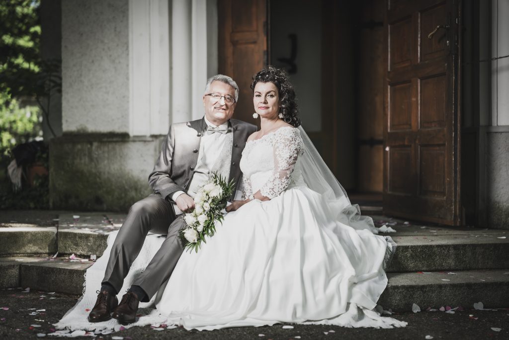 Braut und Bräutigam vor der Kirche - Braut und Bräutigam vor Kirchenportal - Hochzeitsfotograf München Chiemsee